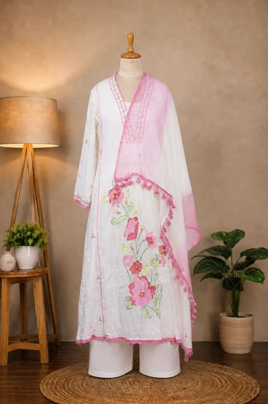 Shop Subi Trends’ white floral embroidered cotton blend A-line suit set with a soft off-white kurta, matching pants and lightweight dupatta.